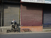 A Kashmiri man sits before closed shops during shutdown in Srinagar, Indian Adminsitered Kashmir on 31 October 2020. Shutdown call was given...