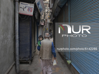 A Kashmiri man carries a kid during shutdown in Srinagar, Indian Adminsitered Kashmir on 31 October 2020. Shutdown call was given by pro fre...
