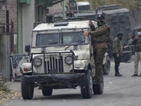 An Indian policeman stands atop police vehilcle near encounter site in Rangreth area on the outskirts of Srinagar, Kashmir on 01 November 20...