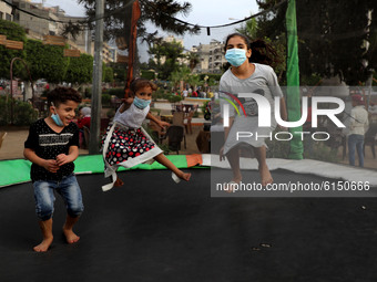 Palestinian children wearing a face mask, play in a public park, in Gaza City on November 1, 2020.  (