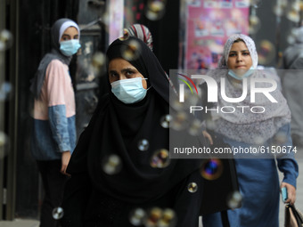 Palestinians, some of them wearing face masks, walk in a market in Gaza City on November 1, 2020.  (