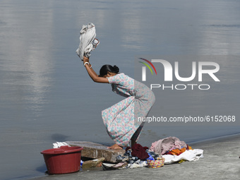 A woman washing clothes in the banks of Brahmaputra river, in Guwahati, India on 02 November 2020.  (