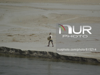 An indian fisherman moves towards river bank of River Gangga to catch fishes during a hot day in Allahabad on June 1,2015. (
