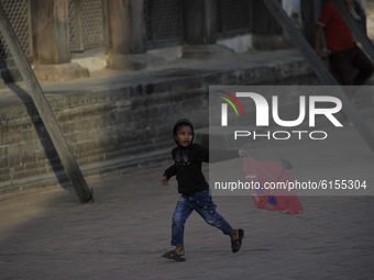 A Little kid tries to fly a kite in the Bhaktapur Durbar Square premises, Bhaktapur, Nepal on November 03, 2020. (