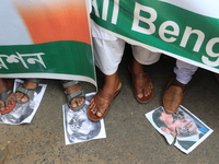 Supporters of All Bengal Minority Youth Federation demonstrators shout slogans and Protesters walk over posters of French President Emmanuel...