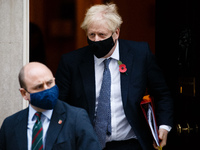 British Prime Minister Boris Johnson wears a face mask and remembrance poppy as he leaves 10 Downing Street heading for his weekly Prime Min...