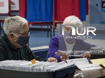 Election Monitor Gloria Pilotte, right, oversees the checking of absentee ballots after polls closed at the Bishop Leo E. ONeil Youth Center...