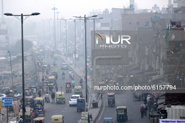 Vehicular traffic passing through amid a layer of smoky haze, as the air quality of the national capital hit 'very poor' levels due to stubb...