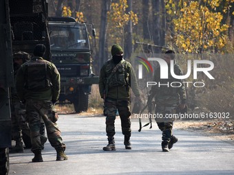 Indian army soldiers walk near the site of gun-battle in Meej area of Pampore in south Kashmir on November 06, 2020. Two militants and a civ...