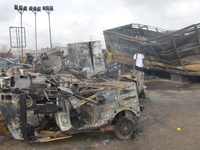 Passersby walk amid burned cars after a tanker exploded on Lagos-Ibadan Expressway on November 7, 2020 in Ogun state killing two people in a...