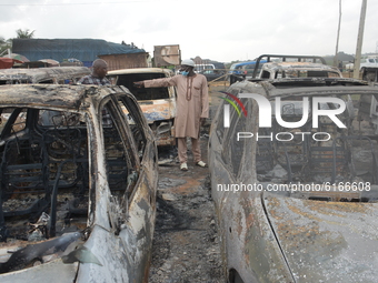 People stand next to burned cars after a tanker exploded on Lagos-Ibadan Expressway on November 7, 2020 in Ogun state killing two people in...