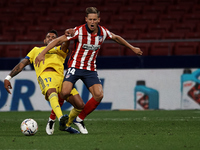 Marcos Llorente of Atletico Madrid and Augusto Fernandez of Cadiz compete for the ball during the La Liga Santader match between Atletico de...