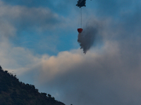 A helicopter of the Government Flying Service of Hong Kong drops water on the flanks of Kowloon Peak, on November 8, 2020. The mountain is t...
