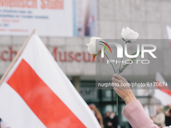 flowers are hold during the protest for pro democracy and ending dictatorship in Belarus in Cologne, Germany, on November 8, 2020. (