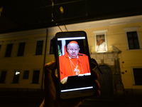 An illustrative photo with a portraitof Cardinal Stanislaw Dziwisz seen on a mobile phone, in front of Krakow Bishops’ Palace in Franciszkan...