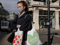 People wear mask as they walk along Regent Street, in London on November 2, 2020. (