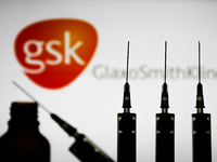 Medical syringes are seen with GlaxoSmithKline company logo displayed on a screen in the background in this illustration photo taken in Pola...