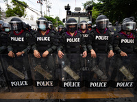 A riot police wear gas masks and anti-riot gear stand guard during a rally outside the Parliament in Bangkok to call for the ouster of Prime...