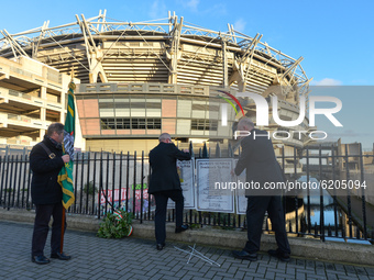 Two men fixing posters with names of Bloody Sunday victimes to the fence outside Croke Park in Dublin, during a commemoration event organise...