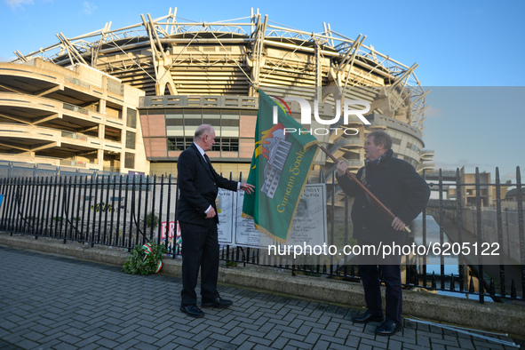Two men seen near posters with names of Bloody Sunday victimes attached to the fence outside Croke Park in Dublin, during a commemoration ev...