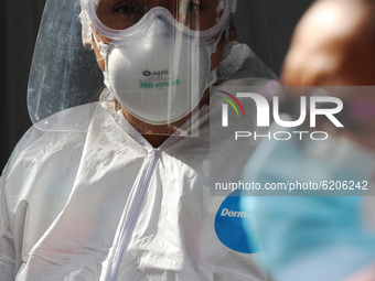 A Health worker wears Personal Protective Equipment (PPE) while makes a rapid test to a person to detect the SARS-Cov2 that causes the COVID...