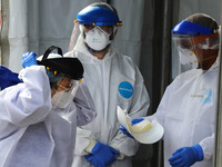 A Health worker wears Personal Protective Equipment (PPE) while makes a rapid test to a person to detect the SARS-Cov2 that causes the COVID...