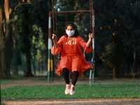 A girl play on a swing at a park amid the COVID-19 coronavirus pandemic in Dhaka, Bangladeah on November 23, 2020. (