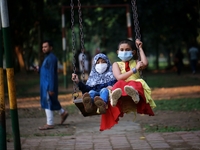 Girls play on swing at a park amid the COVID-19 coronavirus pandemic in Dhaka, Bangladeah on November 23, 2020.  (