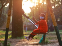 A girl play on a swing at a park amid the COVID-19 coronavirus pandemic in Dhaka, Bangladeah on November 23, 2020. (