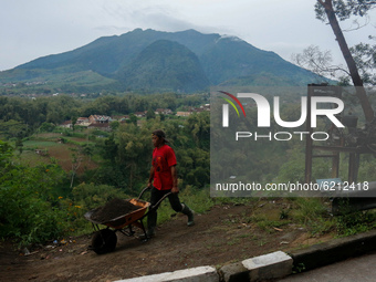 A worker mining sand against the background of mount merapi at Boyolali, Central Java, Indonesia on November 23, 2020. The Indonesian Geolog...