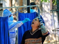 A medic collects swab sample of a man for the COVID-19 test, at Kawatia Hospital  in Jaipur , Rajasthan,India on Monday, Nov 23,2020.(