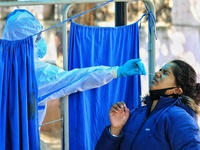 A medic collects swab sample of a girl for the COVID-19 test, at Kawatia Hospital  in Jaipur , Rajasthan,India on Monday, Nov 23,2020.(