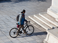 A bicyclist wears a mask at the Syntagma square, in Athens, Greece, on November 23, 2020 amid teh Covid-19 pandemic. (