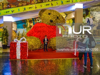 A woman takes pictures of her son in front of an illuminated decoration at a shopping mall on November 23, 2020 in Ankara, Turkey. (