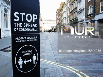 A coronavirus warning sign stands on King Street in the Covent Garden area of London, England, on November 23, 2020. Across England non-esse...