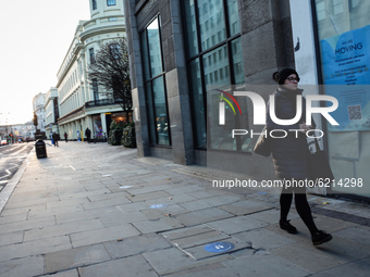 A woman walks past a vacant retail unit on a quiet Strand in London, England, on November 23, 2020. Across England non-essential shops as we...