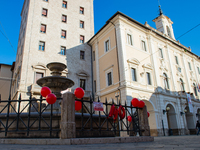 Many red balloons to say No to violence against women on an international day of remembrance. The facade of the Town Hall of Rieti, Italy, o...