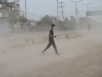 Peoples walk through a dusty busy road in Dhaka, Bangladesh, on November 25, 2020. The air condition of Dhaka city is worsening day by day a...