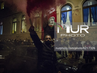 A man holds a smoking flare during a march to protest against the eviction of the occupied social space 