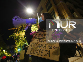 A woman with face mask and a megaphone shows a sign with the name of a women murdered by her ex-couple during the feminist protest against s...
