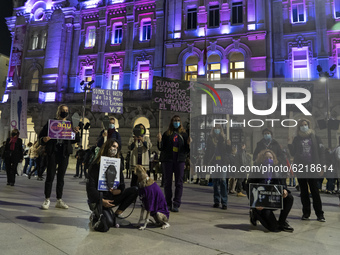 A group of women poses in front of the city hall of Santander illuminated in purple in the rally for the international day for the eliminati...