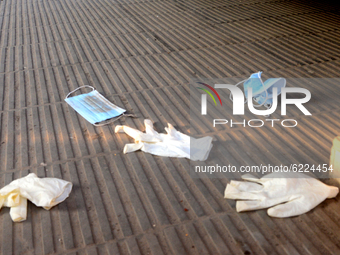 Face masks and hand gloves are seen dumped in front of a hospital's entry point during the COVID-19 coronavirus pandemic in Dhaka, Banglades...