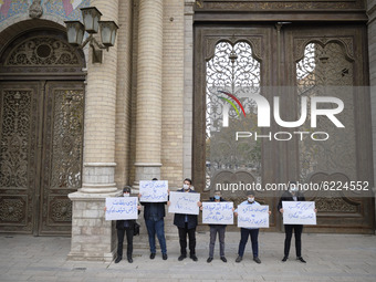 Protesters hold placards while attending a protest gathering against the assassination of the Iranian Top nuclear scientist and a member of...
