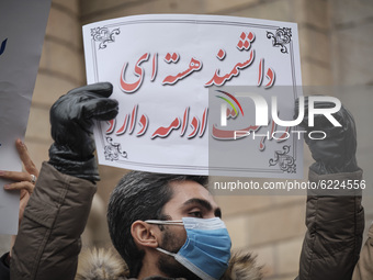 A protester holds a placard with a Persian script that said, The way of the nuclear scientist will be continue, while attending a protest ga...