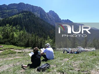  Tatry Mountains in South site of Poland. 05 Jun, 2015, Zakopane
People rest and read books on a mountain slope (
