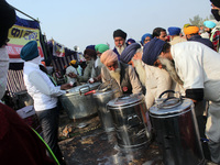 Farmers have tea in a 'Langar', on the occasion of the 551st birth anniversary of Guru Nanak Dev, during a protest against the Centre's new...