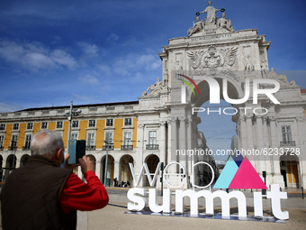 A man wearing a face mask takes a picture of a 3D logo of Web Summit in downtown Lisbon, Portugal on November 30, 2020. Web Summit, Europes...