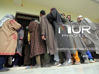 Voters in queue to cast their votes during the second phase of District Development Council (DDC) election in Lalpora area of north Kashmir...