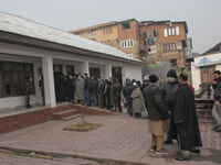 People stand in line outside a voting booth duirng second phase of DDC, ULP elections in Srinagar, Indian Administered Kashmir on 01 Decembe...