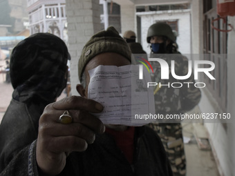 A voter displays his voting slip before casting his vote outside voting booth duirng second phase of DDC, ULP elections in Srinagar, Indian...